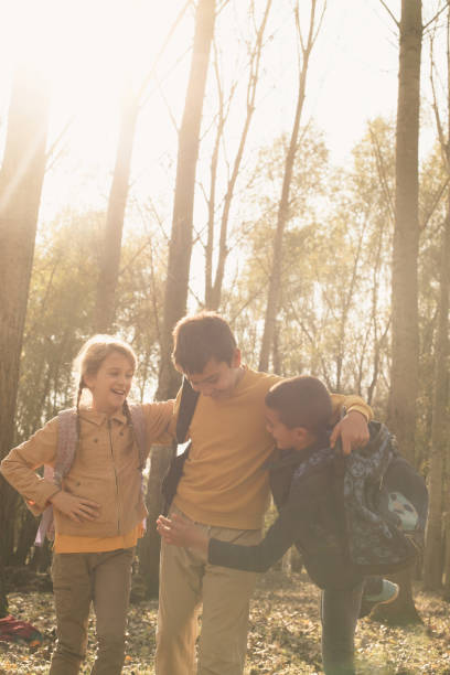 istock Three smiling kids standing in the park an looking each other after school. 689288048