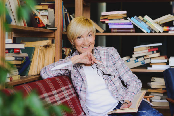 istock Beautiful woman with glasses reading a book 689288262