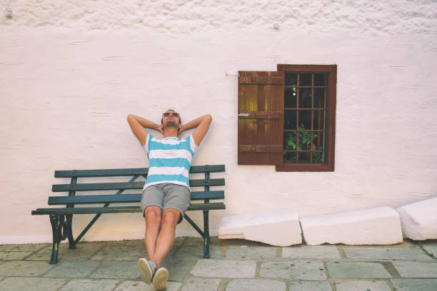 Handsome man sitting on the bench. Enjoying and relaxing.