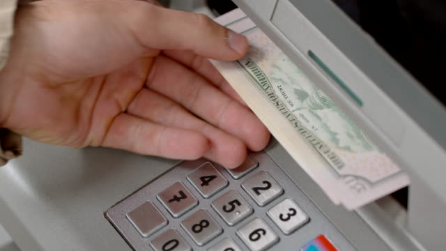 Hands of a person making a cash withdrawal at an ATM