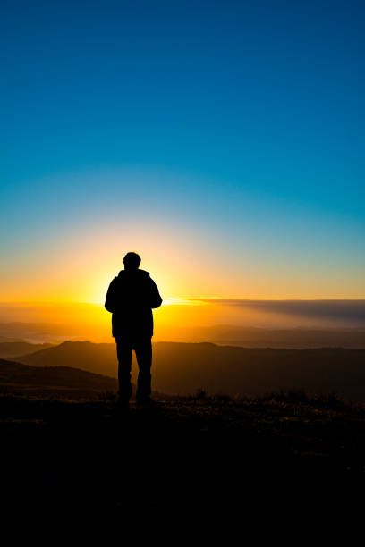 istock Photographer silhouette recording sunrise in mountains 689320472