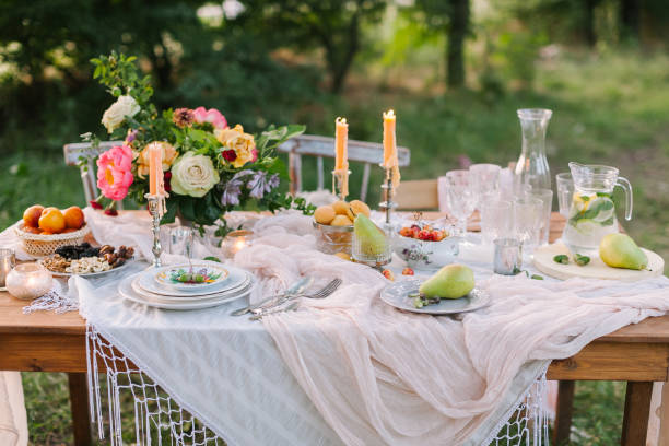 istock wedding, decoration, celebration, floral design, holidays concept - romantic table setting with white tablecloth, plates, crystal goblets, beautiful bouquet of roses and peonies and candels 689323468