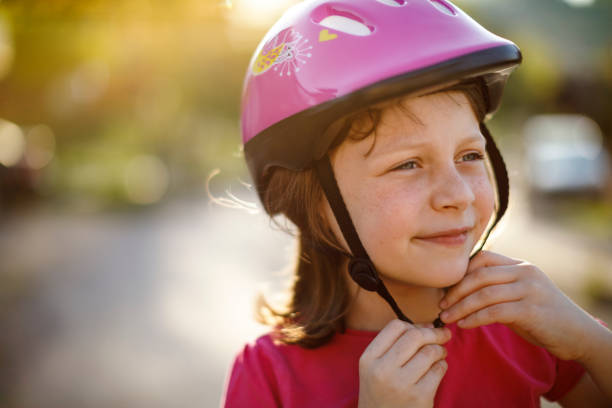 istock Happy cute girl putting cycle helmet on 689331778