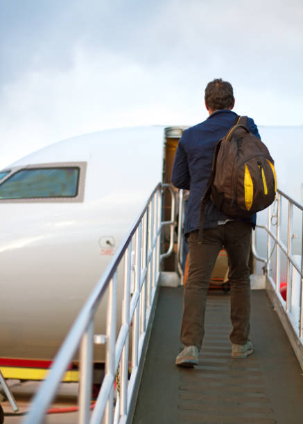istock Active Senior with Backpack Boards Small Plane on Outdoor Ramp 689333874