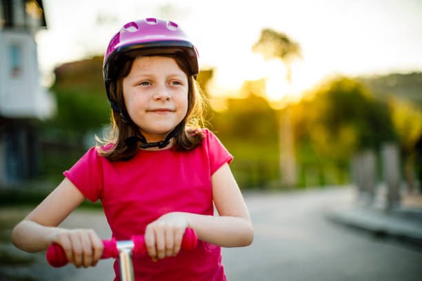 istock Cute happy girl riding push scooter 689334018