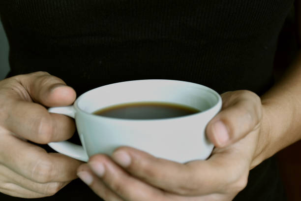 istock Close-up young woman holding cup in hand. (shallow DOF; color toned image) 689340722