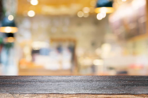istock Empty wooden table for present product on coffee shop or soft drink bar blur background with bokeh image 689344216