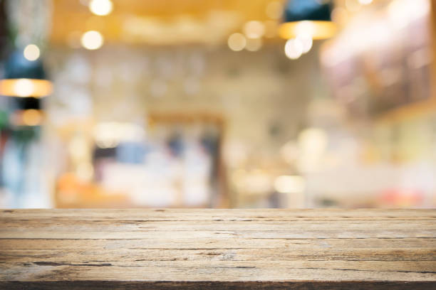 istock Empty wooden table for present product on coffee shop or soft drink bar blur background with bokeh image 689344220