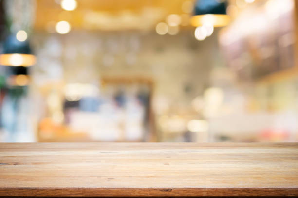 Empty wooden table for present product on coffee shop or soft drink bar blur background with bokeh image