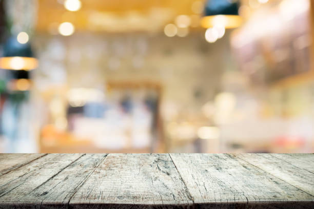 istock Empty wooden table for present product on coffee shop or soft drink bar blur background with bokeh image 689344224