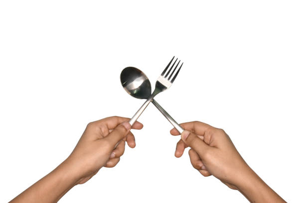 istock Women's hand holds spoon and fork made of aluminum. 689346678