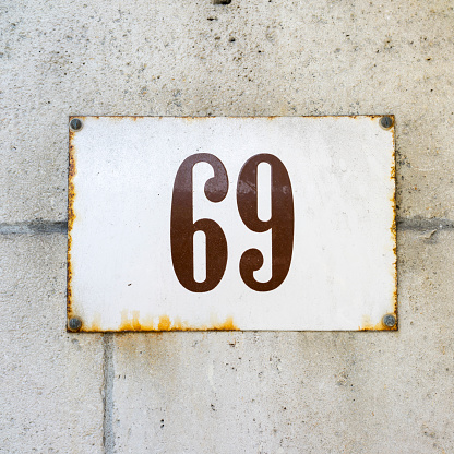 enameled house number on a wall of natural stone