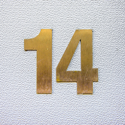 House number fourteen cut out of brass.