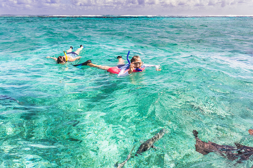 Caye Caulker: People are snorkeling at the reef near Caye Caulker in Belize. It is a small island near Ambergris Caye. The island is very popular with divers because of its close proximity to the Belize Barrier Reef.