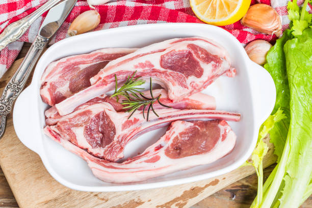 istock Raw lamb chops with spices and herbs close-up on wooden background 689379896