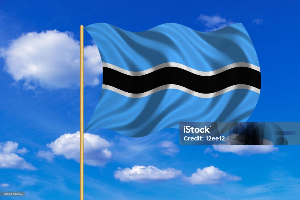 Flag of Botswana waving on blue sky background Botswanan national official flag. African patriotic symbol, banner, element, background. Correct colors. Flag of Botswana on flagpole waving in the wind, blue sky background. Fabric texture Africa stock illustration