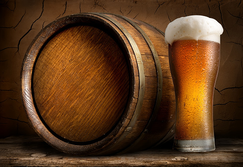Beer in cask and glass on wooden table