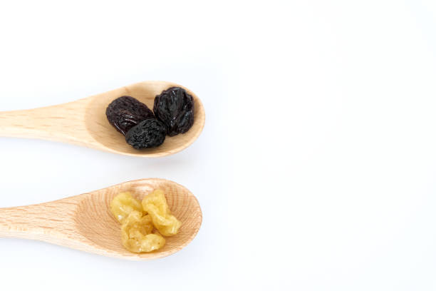 Golden dried raisins isolated on white background.