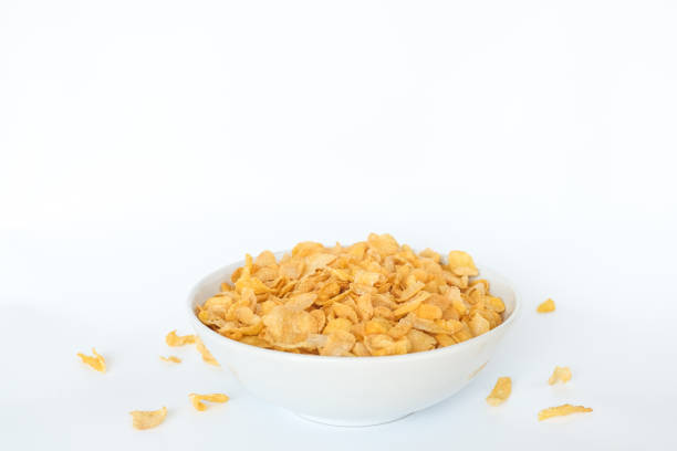 istock Corn flakes falling in bowl isolated on white background 689394454
