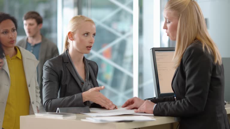 Woman complaining about the bank statement and the bank teller is trying to resolve the situation