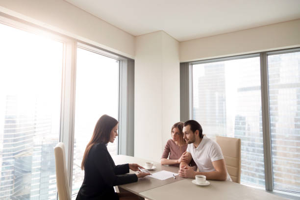istock Young couple and real estate agent manager discussing contract agreement 689401632