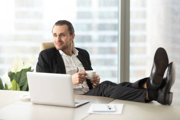 istock Businessman with coffee imagines happy future 689425556