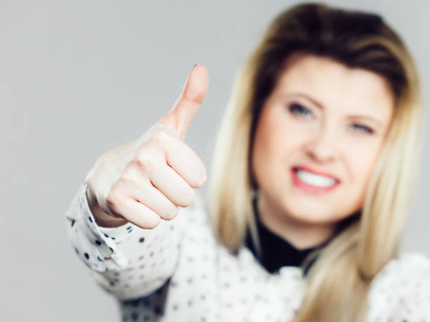 istock Happy positive blonde woman showing thumb up gesture 689428098