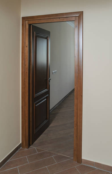 Open a door to a room. The door is made of natural wood.