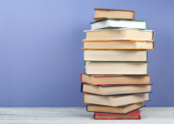 istock Open stacking book, hardback colorful books on wooden table and blue background. Back to school. Copy space for text. Education business concept 689438848
