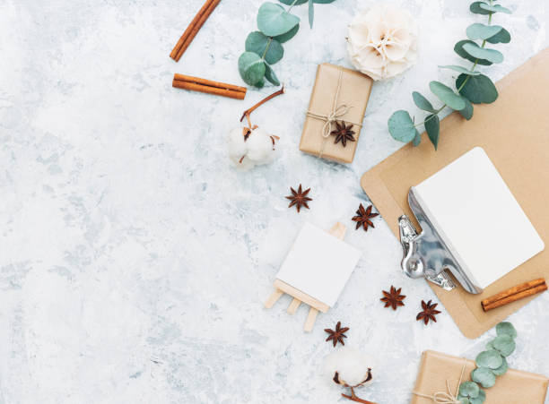 istock Gift or present box wrapped in kraft paper and green leaves on gray table from above. Flat lay styling. Copy space for text. 689440910