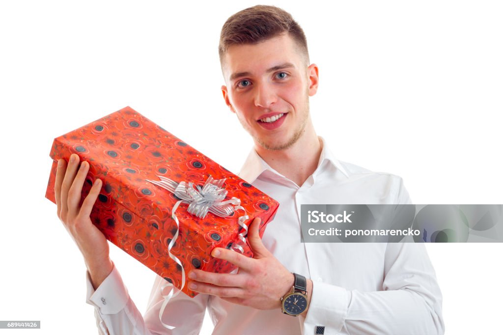 wonderful young guy in shirt smiling and holding a gift close-up wonderful young guy in shirt smiling and holding a gift close-up isolated on white background Adult Stock Photo