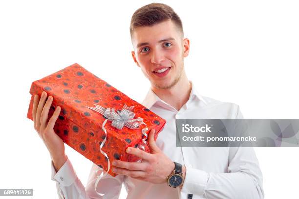 Wonderful Young Guy In Shirt Smiling And Holding A Gift Closeup Stock Photo - Download Image Now