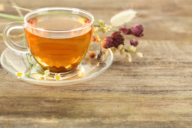 istock Tea and flowers on wooden background 689453518