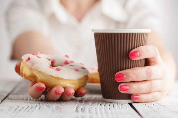 istock Female hand holding delicious donut 689459580