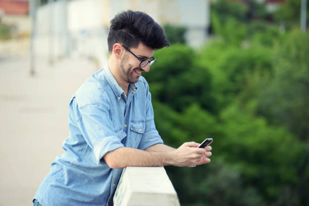 istock Handsome young man using mobile phone on the street 689466348