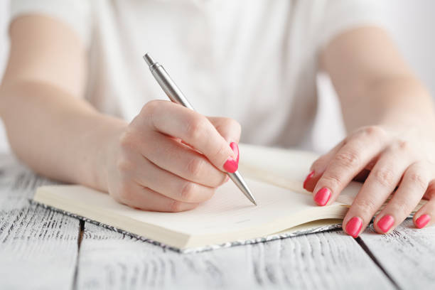 istock Young female is writing notes and planning her schedule 689466378