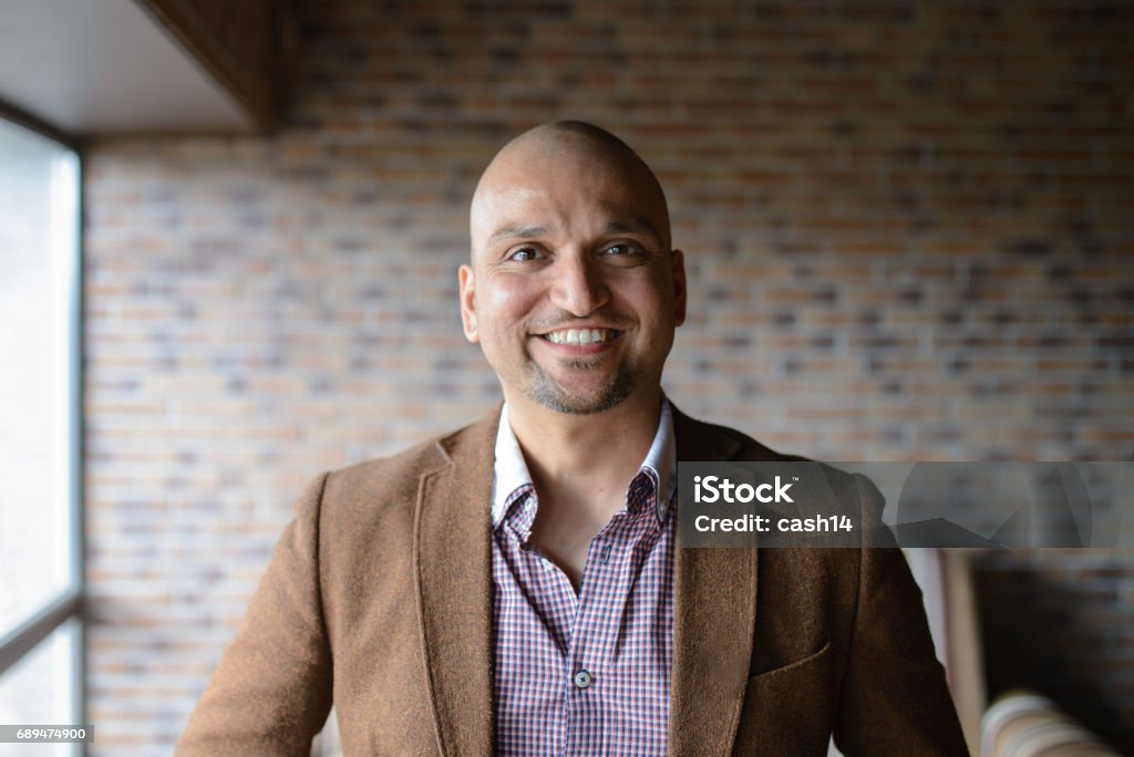 Portrait of happy handsome indian business man, smiling, confident and friendly indoors. Closeup headshot portrait, happy handsome indian business man, smiling, confident and friendly indoors Headshot Stock Photo