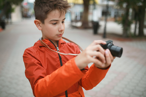 Photo of boy with camera on th street