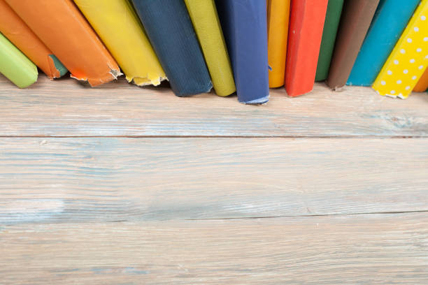istock Book stacking. Open hardback books on wooden table and blue background. Back to school. Copy space for ad text 689490842