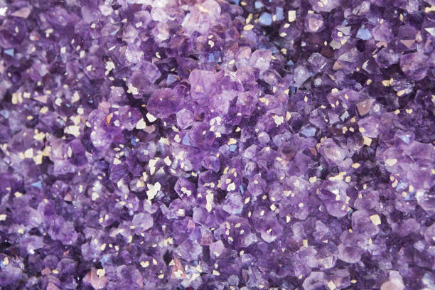 Violet Purple Amethyst Quartz Crystal Geode Purple amethyst quartz crystal semi-precious stone facets protrude from a larger geode, close-up, full frame. geode photos stock pictures, royalty-free photos & images