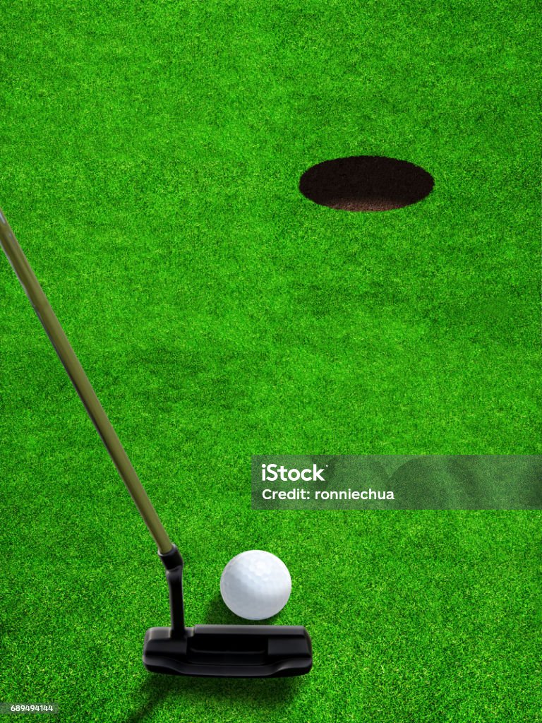 Putting Golf Ball Close to Hole With Copy Space Golfer using a putter club to hit a relatively short and low-speed stroke on golf ball at short distance to hole with copy space. Vertical orientation. Backgrounds Stock Photo