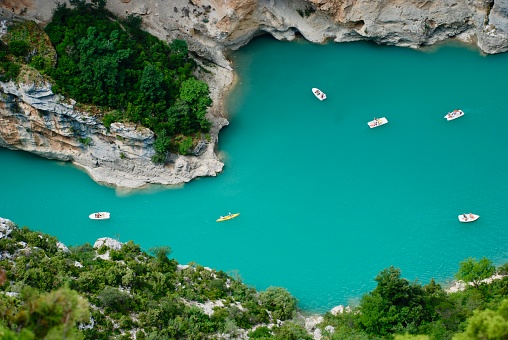 Verdon, France - July 7, 2011: Tourists enjoying a warm summer day in the turquoise waters at Gorges du Verdon; renting boats to explore the gorges or going for a swim.