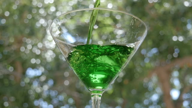 Bright Green Appletini Pours into a Martini Glass