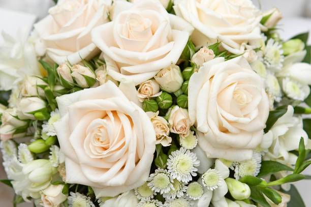 Original wedding rings on beautiful white roses wedding bouquet. stock photo