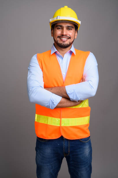 istock Studio shot of young bearded Persian man construction worker against gray background 689514680