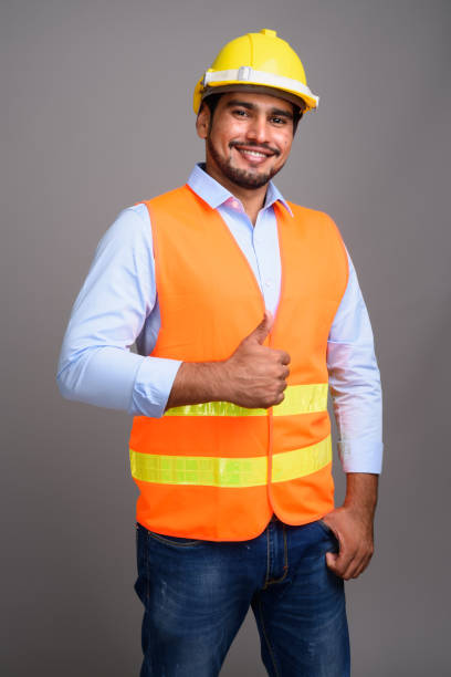 istock Studio shot of young bearded Persian man construction worker against gray background 689514702
