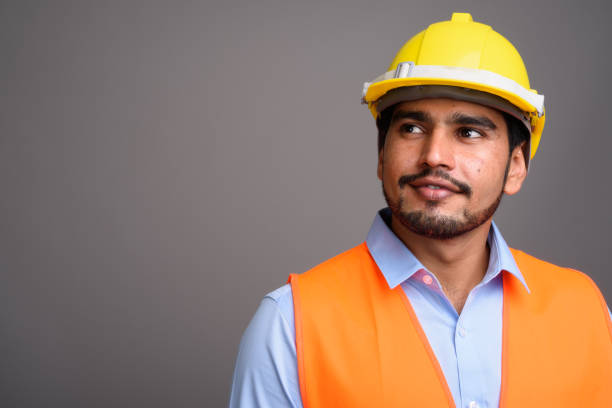 istock Studio shot of young bearded Persian man construction worker against gray background 689514706
