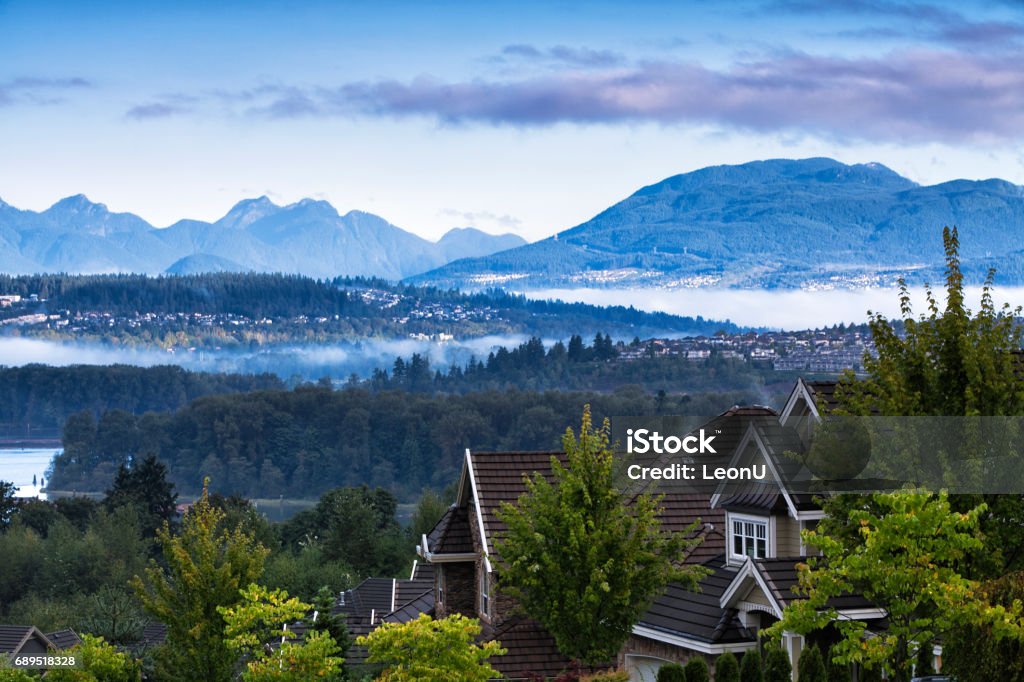 Beautiful mountain river scene at sunrise, BC, Canada Residential area at Surrey near Fraser river in autumn in a early morning, Coquitlam cityscape in the background. British Columbia Stock Photo