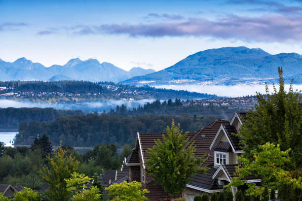 Beautiful mountain river scene at sunrise, BC, Canada Residential area at Surrey near Fraser river in autumn in a early morning, Coquitlam cityscape in the background. british columbia stock pictures, royalty-free photos & images