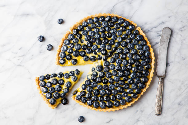 Blueberry tart on marble board Top view Copy space Blueberry tart with vanilla custard on a marble board. Top view. Copy space. bilberry fruit stock pictures, royalty-free photos & images